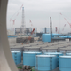 Storage tanks for contaminated water are seen through a window of a building during a media tour to the tsunami-damaged Fukushima nuclear power plant. (Image: AP)